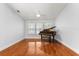 Bright living room area features hardwood flooring, a piano, and bright natural light at 10809 Cedar Cove Drive, Thonotosassa, FL 33592