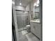Contemporary bathroom featuring a large glass shower, white cabinets, and gray tiling at 1427 Hyssop Loop, North Port, FL 34289
