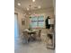 Neutral dining area with modern chandelier over a table set for four near a large window at 1427 Hyssop Loop, North Port, FL 34289