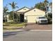 Charming single-story home with a two-car garage, brick driveway, landscaped yard, and palm trees at 1427 Hyssop Loop, North Port, FL 34289