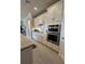 Kitchen with stainless steel appliances, white cabinetry, granite countertops, and tiled backsplash at 1427 Hyssop Loop, North Port, FL 34289