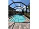 Screened-in pool with brick pavers, attached spa, and seating area at 1427 Hyssop Loop, North Port, FL 34289