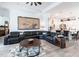 Spacious living room with tile floors, a leather sectional sofa, and a view of the kitchen at 25301 Longmeadow Dr, Punta Gorda, FL 33955