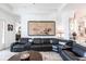 Elegant living room with a comfortable leather sectional, a round coffee table, and a view of the kitchen at 25301 Longmeadow Dr, Punta Gorda, FL 33955