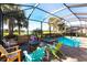 Relaxing screened pool area with comfortable lounge furniture, a hot tub, and beautiful lake views at 25301 Longmeadow Dr, Punta Gorda, FL 33955