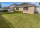 Well-maintained backyard with lush green grass, neat landscaping, and a white fence for privacy at 4914 Trinidad Dr, Land O Lakes, FL 34639