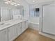 Bright bathroom featuring double sinks, spacious vanity, bathtub, and glass walk-in shower at 4914 Trinidad Dr, Land O Lakes, FL 34639