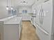 Bright kitchen features white cabinetry, stainless appliances, and a spacious countertop with bar stool seating at 4914 Trinidad Dr, Land O Lakes, FL 34639