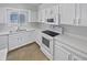 Updated kitchen features modern white appliances and cabinetry, with neutral countertops and tile flooring at 4914 Trinidad Dr, Land O Lakes, FL 34639