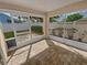 Enclosed patio featuring brick flooring and views of the landscaped backyard through screened windows and a pet door at 4914 Trinidad Dr, Land O Lakes, FL 34639