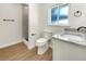Modern bathroom featuring a walk-in shower, granite countertop vanity, and wood-look floors at 961 Charlotte Ave, Sarasota, FL 34237