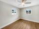 Bright bedroom featuring wood-look flooring, fresh paint, two large windows, and a ceiling fan at 961 Charlotte Ave, Sarasota, FL 34237