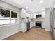 Modern kitchen featuring stainless steel appliances, granite countertops, white cabinets, and wood-look floors at 961 Charlotte Ave, Sarasota, FL 34237