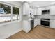 Bright kitchen features stainless appliances, white cabinetry, and updated countertops at 961 Charlotte Ave, Sarasota, FL 34237