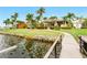 Spacious backyard with lush landscaping that leads to a stone rock wall and a private dock on the water at 5405 Merritt Island Dr, Apollo Beach, FL 33572