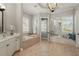Luxurious bathroom with soaking tub, vanity, and window bench with pool view at 5405 Merritt Island Dr, Apollo Beach, FL 33572