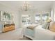Bright bedroom with plantation shutters, a modern chandelier, and view of the pool and waterfront at 5405 Merritt Island Dr, Apollo Beach, FL 33572