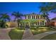 Stately two-story home with covered porch, lush landscaping, and circular driveway at dusk at 5405 Merritt Island Dr, Apollo Beach, FL 33572