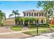 Two-story home with a covered porch, large driveway, and lush tropical landscaping at 5405 Merritt Island Dr, Apollo Beach, FL 33572