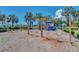 Fun playground with slides, swings, and climbing structures set amongst mature palm trees at 5405 Merritt Island Dr, Apollo Beach, FL 33572