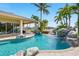 Beautiful backyard pool featuring a rock waterfall, lush landscaping, and a tranquil water view at 5405 Merritt Island Dr, Apollo Beach, FL 33572