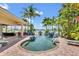 Inviting backyard pool area with rock features, lush greenery, and serene water views at 5405 Merritt Island Dr, Apollo Beach, FL 33572