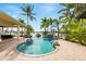 Backyard pool and patio featuring a tranquil rock waterfall with palm trees and a view of the water at 5405 Merritt Island Dr, Apollo Beach, FL 33572