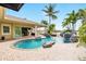 Backyard pool with a rock waterfall feature, brick patio, covered porch, and stunning views at 5405 Merritt Island Dr, Apollo Beach, FL 33572