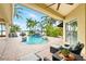 Inviting pool area with palm trees, a waterfall feature, and comfortable outdoor seating overlooking the water at 5405 Merritt Island Dr, Apollo Beach, FL 33572