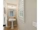 Charming powder room featuring a pedestal sink and elegant lighting, next to a window at 5405 Merritt Island Dr, Apollo Beach, FL 33572