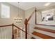 Elegant staircase with wood steps and white banisters, illuminated by a decorative chandelier at 5405 Merritt Island Dr, Apollo Beach, FL 33572