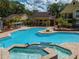 Resort style community pool with hot tub and deck with many lounge chairs at 8653 Fancy Finch Dr # 102, Tampa, FL 33614