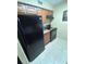 Compact kitchen with tile flooring and black appliances at 8653 Fancy Finch Dr # 102, Tampa, FL 33614