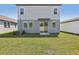 The backyard features a sliding glass door, sodded lawn, and neutral exterior color at 1869 Brekey Way, Zephyrhills, FL 33541