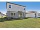 The backyard features a sliding glass door, sodded lawn, and neutral exterior color at 1869 Brekey Way, Zephyrhills, FL 33541