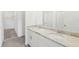 A bathroom with a double sink vanity and a large mirror above the counter, next to the walk-in closet at 1869 Brekey Way, Zephyrhills, FL 33541