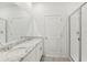 Bathroom featuring double sink vanity with granite countertop and a glass enclosed shower to the right at 1869 Brekey Way, Zephyrhills, FL 33541