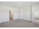 Bright, carpeted bedroom with ensuite bathroom and view into the hall at 1869 Brekey Way, Zephyrhills, FL 33541