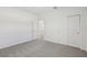 Bright bedroom featuring neutral carpet, white walls, closet, and a doorway to a hall or adjoining room at 1869 Brekey Way, Zephyrhills, FL 33541