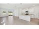 Bright, open-concept kitchen with white cabinets, granite countertops and stainless steel appliances at 1869 Brekey Way, Zephyrhills, FL 33541