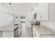 Well-lit kitchen with a large center island, stone countertops, and stainless steel appliances at 1869 Brekey Way, Zephyrhills, FL 33541