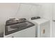 Modern laundry room with a front-load washer and dryer and wire shelving at 1869 Brekey Way, Zephyrhills, FL 33541