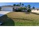 Charming single-story home with well-maintained landscaping and a two-car garage, showcasing curb appeal at 89 Mark Twain Ln, Rotonda West, FL 33947