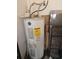 An electric hot water heater sits in the corner of a room with a cart and other stored items at 18660 White Pine Cir, Hudson, FL 34667