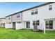 Townhome backyard featuring a green lawn, white fences, and modern exterior at 7270 Deer Valley Cir, Tampa, FL 33635
