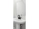 Modern half bathroom with pedestal sink, black faucet and hardware, and large mirror at 7270 Deer Valley Cir, Tampa, FL 33635
