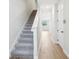 Bright hallway with gray carpet stairs and wood-look tile flooring throughout at 7270 Deer Valley Cir, Tampa, FL 33635