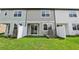 A backyard with lush grass, a white fence and gray siding at 7272 Deer Valley Circle, Tampa, FL 33635