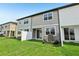 A backyard with lush grass, a white fence and gray siding at 7272 Deer Valley Circle, Tampa, FL 33635
