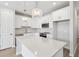 Bright kitchen features white cabinets, stainless steel appliances, an island with quartz countertop, and modern pendant lighting at 7272 Deer Valley Circle, Tampa, FL 33635